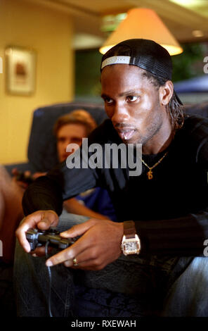 Joueur de Chelsea Didier Drogba à jouer à des jeux vidéo dans un hôtel d'Heathrow en 2005 Banque D'Images