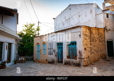 Une vieille maison et une allée baignée de lumière dorée en Grèce Banque D'Images