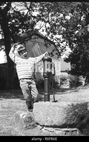 Jeune garçon, environ 7/8 ans, montrant au large de l'appareil photo : North Bovey, Devon, UK. Film en noir et blanc photographie, vers 1994. Parution du modèle Banque D'Images