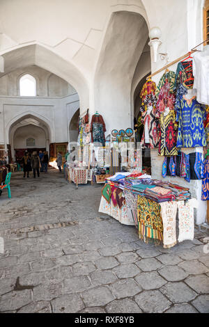 Boukhara, Ouzbékistan - 19 octobre 2016 : Vente de souvenirs dans le dôme du commerce à Boukhara. Les vêtements nationaux, brodé skullcaps, taies, poupée russe Banque D'Images
