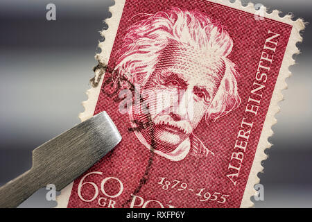 Albert Einstein portrait sur un timbre poste vintage, annulée à partir de la Pologne a tenu par une pince au-dessus de la page de l'album de timbres Banque D'Images