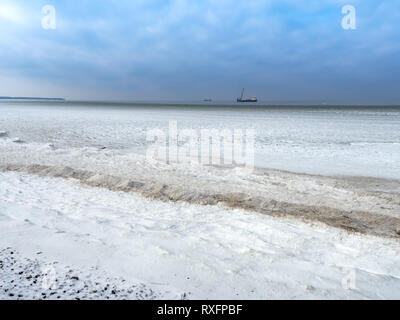 Boues de glace dans la mer, et un navire de mer d'hiver à l'horizon Banque D'Images