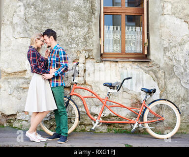 Young attractive tourist couple romantique, barbu et blonde femme debout ensemble en tandem moderne éclairé par le soleil clair un trottoir vide Banque D'Images