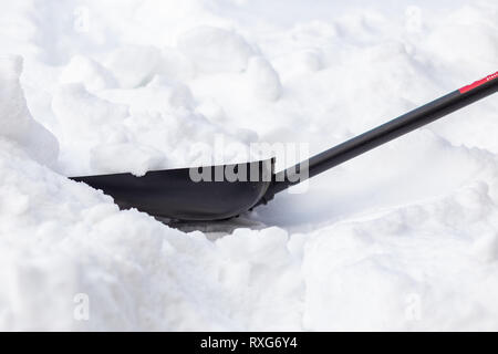 Une pelle à neige est coincé dans un banc de neige sur une journée d'hiver. Close-up, des dérives dans la rue Banque D'Images