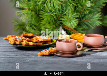 Ginger cookies de Noël près du Nouvel An des arbres sur une table en bois. Close-up, arrangement de fête avec les cookies et les tasses en céramique Banque D'Images