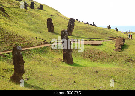 La pente plein de statues Moai géant abandonné du volcan Rano Raraku à l'océan Pacifique en toile de fond, site archéologique de l'île de Pâques, Chili Banque D'Images