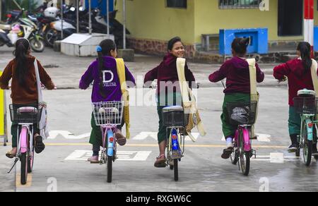 Beijing, la province chinoise du Yunnan. Mar 8, 2019. Les étudiants du Myanmar retour accueil des motos après étude à l'école primaire en Yinjing Yinjing Village de Ruili, sud-ouest de la province chinoise du Yunnan, le 8 mars 2019. L'école primaire Yinjing est située à la frontière de la Chine et le Myanmar et il dispose d'un total de 135 étudiants, dont 36 étudiants du Myanmar. Crédit : Li Xiaoguo/Xinhua/Alamy Live News Banque D'Images