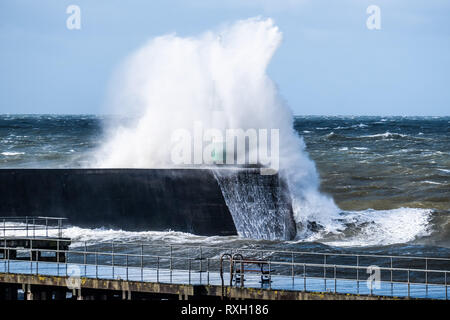 Pays de Galles, Royaume-Uni. 10 mars 2019. Météo France : coup de vent d'ouest avec rafales à plus de 60km/h , et le matin de 4,9m à marée haute , se combinent pour faire d'énormes vagues déferle sur la mer d'Irlande et battues dans la défense de la mer à Aberystwyth, sur la côte de la Baie de Cardigan, West Wales UK Crédit photo : Keith Morris /Alamy Live News Banque D'Images