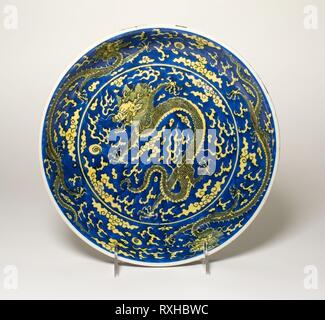 Blue-Ground Yellow-Enameled 'dragon' plat. La Chine. Date : 1662-1722. Dimensions : H. 4,1 cm (1 5/8 in.) ; diam. 25,1 cm (9 7/8 in.). Porcelaine peinte en bleu et jaune sous glaçure overglaze émail. Origine : Chine. Musée : le Chicago Art Institute. Banque D'Images