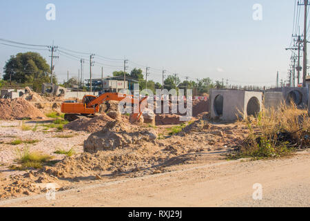 Les pelles sont en train de creuser le sol pour mettre en place un grand tuyau de drainage près de la route dans la zone de la ville Banque D'Images