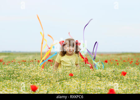 Happy little girl fun et forme avec des rubans colorés sur prairie de la saison du printemps Banque D'Images