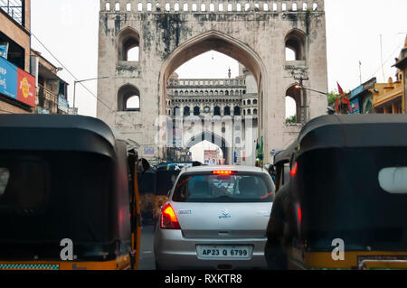 Prises de l'intérieur d'une voiture en mouvement. Charminar encadrée par Char Kaman, qui à son tour est encadrée par deux auto-pousse (tuk-tuks). Hyderabad, Inde, Telangana. Banque D'Images