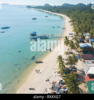 Drone aérien Vue de longue plage de sable blanc île tropicale, village de pêcheurs traditionnels malais. Mantanani Island Sabah Malaisie Bornéo. Banque D'Images