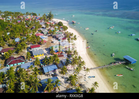 Drone aérien Vue de longue plage de sable blanc île tropicale, village de pêcheurs traditionnels malais. Mantanani Island Sabah Malaisie Bornéo. Banque D'Images