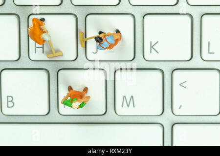 Les gens miniature blanc nettoyage clavier ordinateur. Banque D'Images
