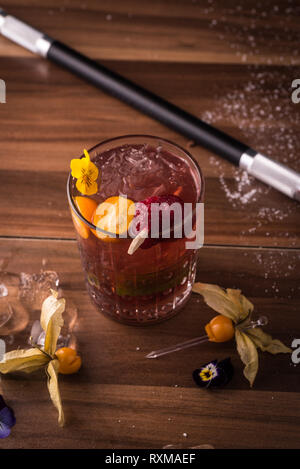 Cocktail de couleur sombre sur fond de bois. Banque D'Images