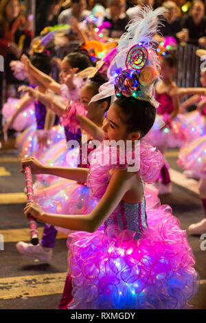 Les filles en robe rose danser dans le cadre de la nouvelle année chinoise / Nouvel An lunaire (année du cochon) à Kowloon, Hong Kong, Chine Banque D'Images