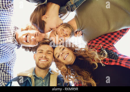 Vue de dessous. Friends hugging et souriant à l'extérieur Banque D'Images