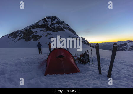 Deux alpinistes manger le dîner tout en regardant le coucher du soleil au camp - Wedge Mountain, parc provincial Garibaldi, British Columbia, Canada Banque D'Images