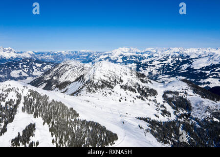 Panorama lumineux de montagnes avec de la neige et de la glace sur le dessus contre le ciel bleu en hiver et de forêts denses à la base de la montagne. Banque D'Images