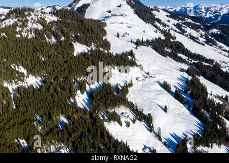 Vue aérienne du vol en parapente sur la neige la forêt de montagne. Vue de dessus. Banque D'Images