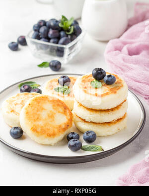 Les gâteaux de fromage cottage, le petit déjeuner délicieux, sweet pancakes russes traditionnels. Avec Blueberry, de menthe et de la sauce Banque D'Images