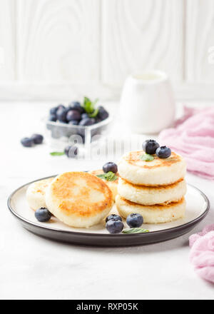 Les gâteaux de fromage cottage, le petit déjeuner délicieux, sweet pancakes russes traditionnels. Avec Blueberry, de menthe et de la sauce Banque D'Images