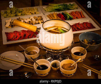 Fondue japonaise dans le restaurant de Kavaliershaus, Fincken, Allemagne.Une fondue spéciale peut être commandée par les invités.Les ingrédients japonais tels que la sauce ponzu rencontrent le bœuf le plus tendre du Mecklembourg.Dans un bouillon miso léger, le boeuf est cuit ainsi qu'une grande sélection de légumes.La sauce au ponzu, la sauce soja et la sauce au sésame sont servies pour l'assaisonnement.Un mélange agréable de légèreté asiatique et d'ingrédients terre à terre de la région. Banque D'Images