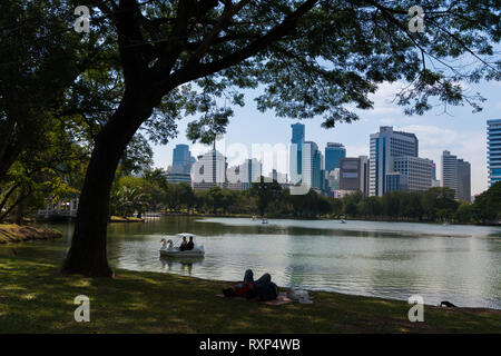 Se détendre sur l'herbe près du lac dans le parc Lumpini, Bangkok, Thaïlande Banque D'Images