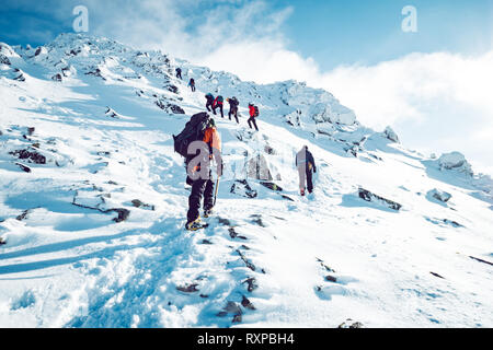 Un groupe de grimpeurs ordre croissant une montagne en hiver Banque D'Images