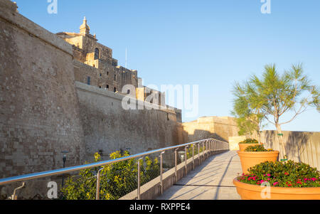 L'extérieur vue sur la citadelle de Victoria du château mur recouvert de fleurs en pot et main courante entouré de grès. Victoria. Gozo. Malte. Banque D'Images