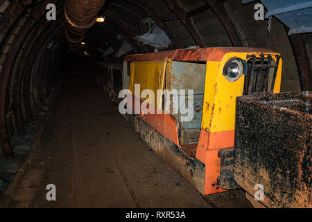 Ancienne mine de métal rouillé et de former avec les chariots dans la mine tunnel avec ses colombages en bois Banque D'Images