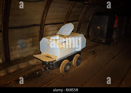 Ancien wagon de toilettes et de métal dans le train de la mine mine tunnel avec ses colombages en bois Banque D'Images