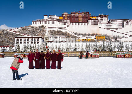 Lhasa, Chine - 19 décembre 2018 : Le bouddhisme tibétain moines posant pour la photo devant le Palais du Potala sur une journée d'hiver ensoleillée au Tibet. Banque D'Images