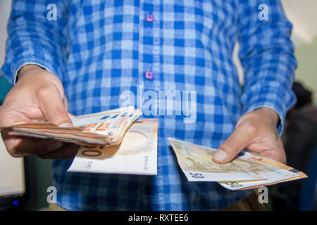 Les mains d'hommes comptant une grande quantité de billets de trésorerie en monnaie euro faible, voir Banque D'Images