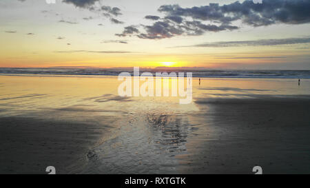 Les gens à pied sur la plage en fin d'après-midi de réflexion au crépuscule dans Cannon Beach Oregon Banque D'Images