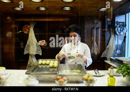 Un cuisinier est vu préparer la morue traditionnelle cakes dans un snack-bar traditionnel dans la vieille ville. En 2018, Porto est entré dans la liste des 100 villes les plus visités dans le monde dans un classement établi par Euromonitor International. En 2018, on estime que le nombre de touristes a atteint 2,39 millions de dollars. Banque D'Images