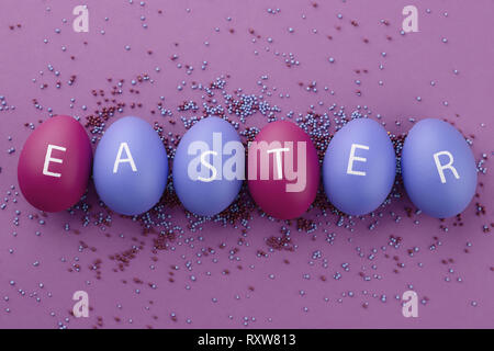 Les oeufs peints avec des lettres disposées en mot Easter Banque D'Images