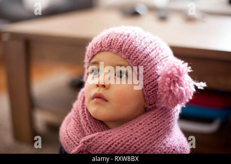 Cute little baby girl wearing purple cap et écharpe en laine Banque D'Images