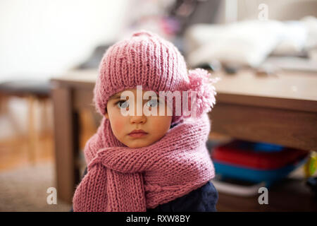 Cute little baby girl wearing purple cap et écharpe en laine Banque D'Images