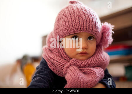 Cute little baby girl wearing purple cap et écharpe en laine Banque D'Images