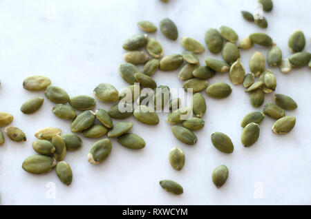 Close up de matières premières graines de citrouille verte sur un fond blanc Banque D'Images