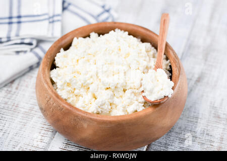 Le fromage cottage ou tvorog à bol en bois sur fond blanc. Riche en calcium produit laitier pour les plus sportifs de vie sain Banque D'Images