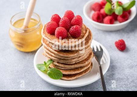 Pile de crêpes aux framboises et miel. Vue rapprochée. Crêpes aux fruits rouges complet Banque D'Images