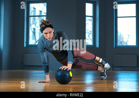 Mettre en place et la femme core intense entraînement avec kettlebell dans une salle de sport. L'exercice au féminin sport crossfit. Banque D'Images