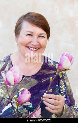 Femme est titulaire d'une branche d'un magnolia Banque D'Images