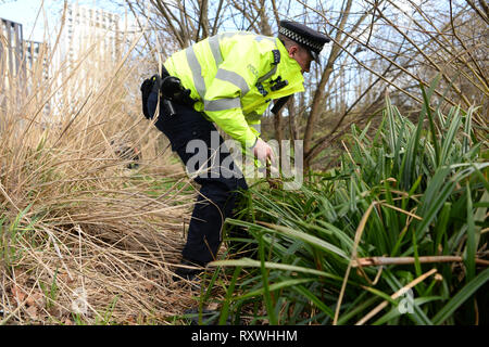 Un fonctionnaire de la Police métropolitaine, recherches d'armes en Cornmill Gardens à Lewisham, dans le sud de Londres, dans le cadre de l'opération de Sceptre, qui verra l'ensemble des forces de l'Angleterre et le Pays de Galles à l'aide d'abandonner des bacs, arrêter-et-search et d'armes balaie dans un effort de sévir contre la criminalité des couteaux. Banque D'Images