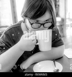 Jeune fille avec le syndrome de Down ayant le thé l'après-midi à White Mill Mariana, Northamptonshire. Banque D'Images