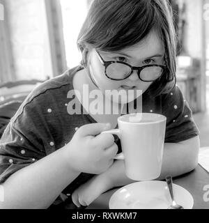 Jeune fille avec le syndrome de Down ayant le thé l'après-midi à White Mill Mariana, Northamptonshire. Banque D'Images