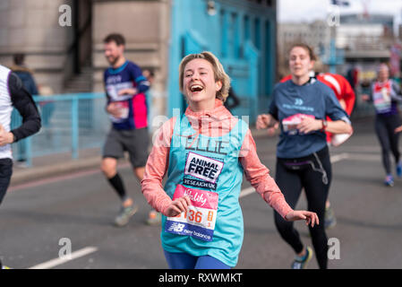 Ellie Hale s'exécutant dans la vitalité demi demi marathon traversant le Tower Bridge, Londres, Royaume-Uni. La recherche de l'animal la charité. Fun runner Banque D'Images